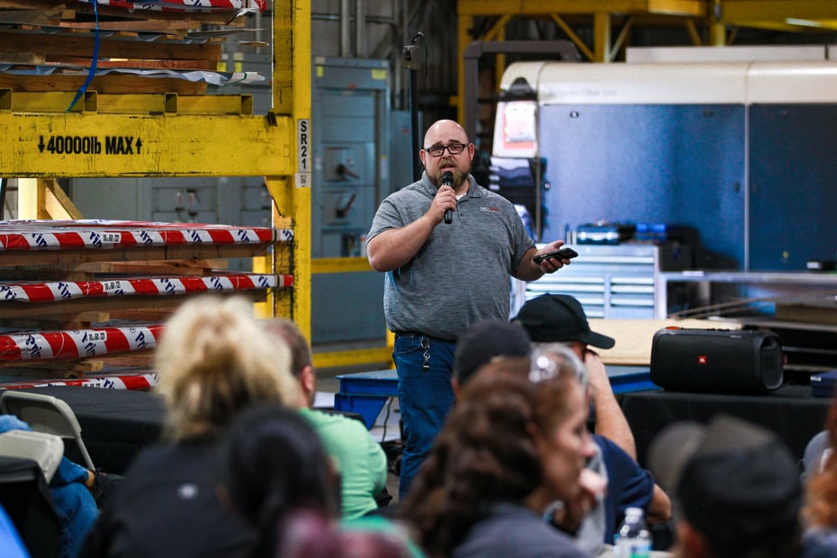 Daniel Webster, COO of NexGen Manufacturing, addresses employees during the Q4 Townhall, discussing operational performance and quality goals.