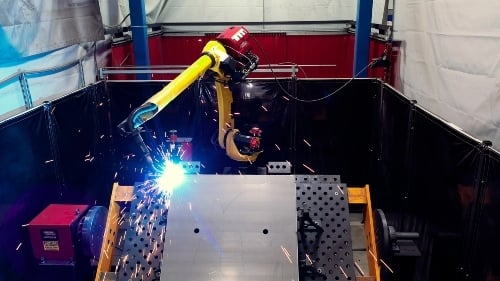 robotic arm welding metal pieces on a workbench in a manufacturing factory in Texas